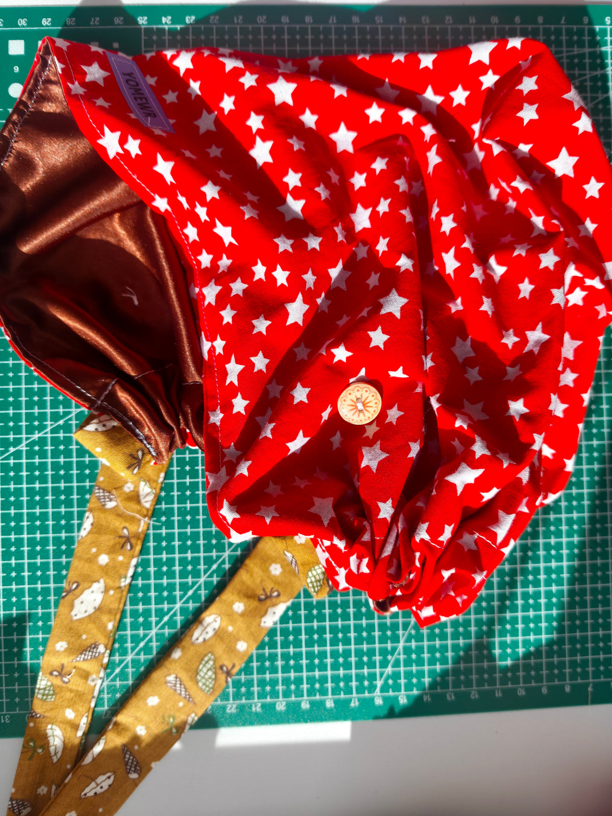 Scrub cap, cotton fabric with a satin inner. Has buttons for the pulls of  your mask to relieve  pressure from your ears