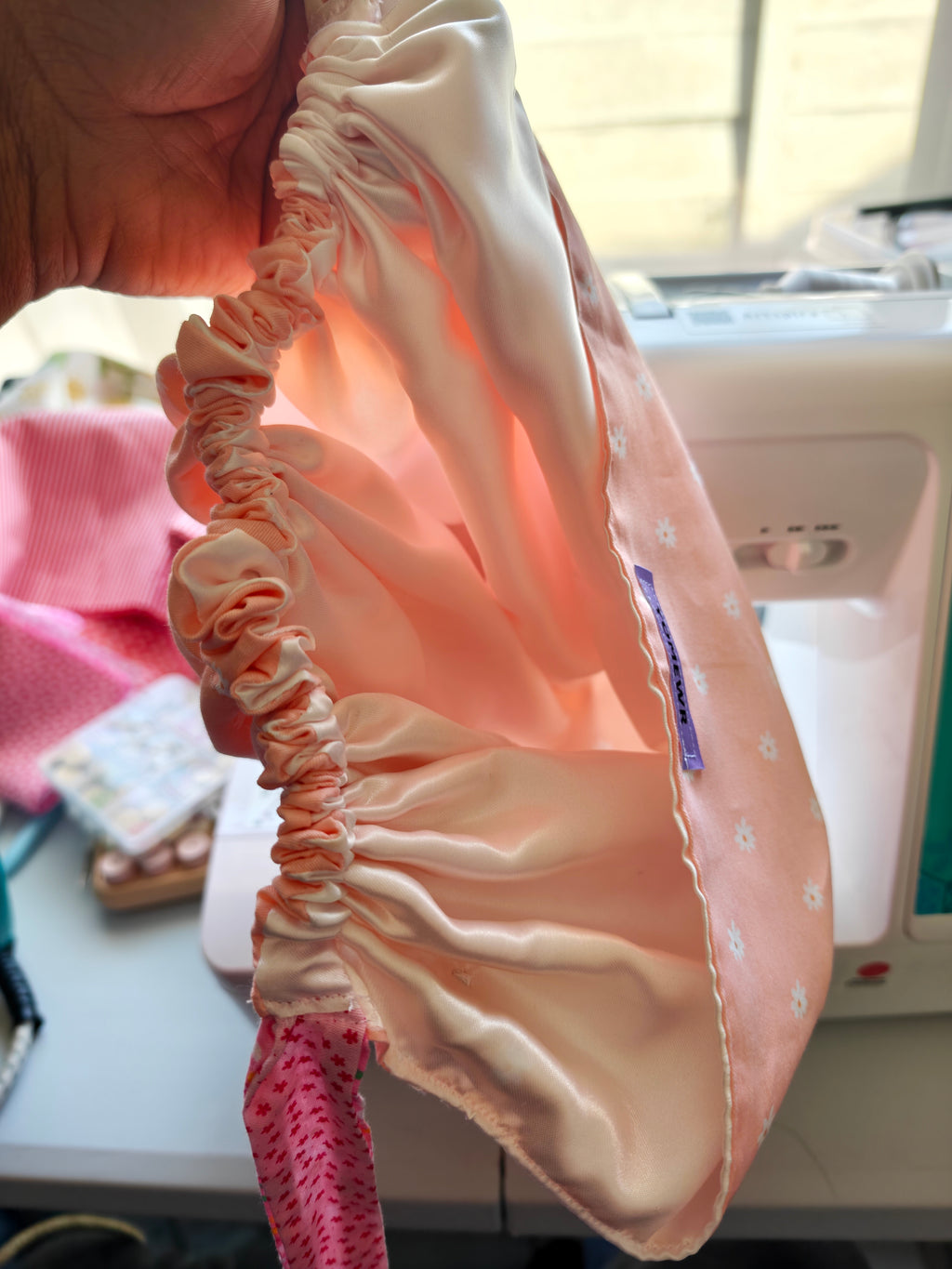 Scrub cap, cotton fabric with a satin inner. Has buttons for the pulls of  your mask to relieve  pressure from your ears