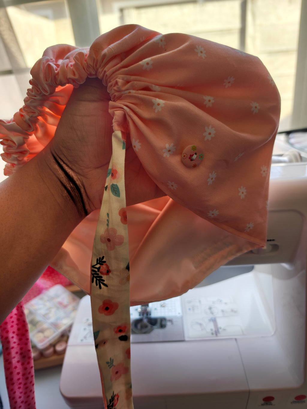 Scrub cap, cotton fabric with a satin inner. Has buttons for the pulls of  your mask to relieve  pressure from your ears